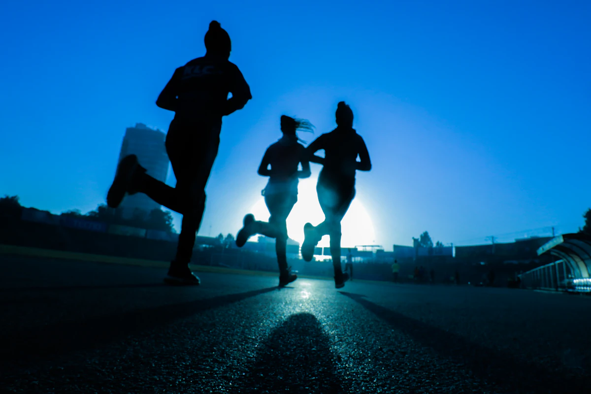 Runner training outdoors at dawn on a shaded path — heat-smart morning workout in Malaysia